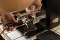 Barista grinding fresh coffee bean into portafilter for espresso