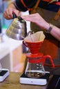 Barista hand pouring hot water into drip coffee maker Royalty Free Stock Photo