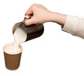 Barista hand, preparing hot milk foam, pourin milk in paper cup with coffee cappuccino