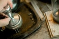 Barista hands hold Portafilter and metal tamper for tampering with manual presses ground coffee Royalty Free Stock Photo