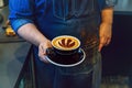 Barista hands holding black cup of coffee cappuccino with Toronto Raptors basketball team logo sign on milk foam