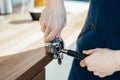 Barista hands holding portafilter and coffee tamper making an espresso coffee.