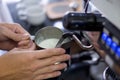 Barista holding pitcher full of milk frothing in the cappuccinatore of coffee machine. Close up Royalty Free Stock Photo