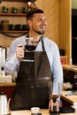 Barista jokes and smiles with syphon coffee making in cafe. Altertanive coffee brewing process.