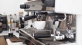Barista makes artistic latte with espresso machine in cafe. Professional modern espresso coffee machine pours hot drink into the