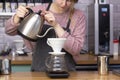 Barista makes espresso using a funnel.