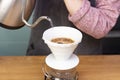 barista makes espresso using a funnel.