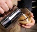 Barista makes latte coffee with milk in cafe closeup Royalty Free Stock Photo