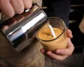 Barista makes latte coffee with milk in cafe closeup Royalty Free Stock Photo