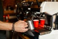 Barista makes Latte coffee on a professional coffee machine