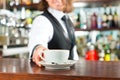 Barista making cappuccino in his coffeeshop