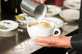 Barista making cappuccino in his coffeeshop