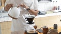 Barista is making drip brewing, filtered coffee, or pour over coffee with hot water and filter paper in coffee shop and drip