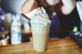 Barista making frappe - iced latte coffee with caramel and chocolate syrup and whipped cream Royalty Free Stock Photo