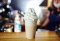 Barista making frappe - iced latte coffee with caramel and chocolate syrup and whipped cream Royalty Free Stock Photo