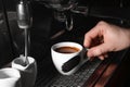 Barista making fresh aromatic espresso using professional coffee machine in cafe, closeup Royalty Free Stock Photo