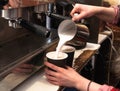Barista making fresh takeaway coffee. Close-up view on hands with portafilter, barista coffee preparation service concept.