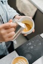 Barista making latte art in specialty coffee shop. Professional man making pouring stream milk with espresso Royalty Free Stock Photo