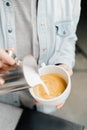Barista making latte art in specialty coffee shop. Professional man making pouring stream milk with espresso Royalty Free Stock Photo