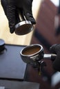 Barista making presses the coffee in the portafilter with temper