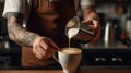 The barista male hands pouring milk and preparing fresh cappuccino