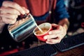 Barista man creating latte art on long coffee with milk. Latte art in coffee mug. Barman pouring fresh coffee