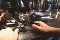 Barista man holding two coffee holders one above the other on coffee machine background close up