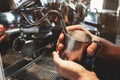 Barista man steaming milk in frothing pitcher using professional coffee machine cappuccinator in cafe Royalty Free Stock Photo