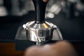 Barista place tamp on top and press it down into the ground coffee Royalty Free Stock Photo