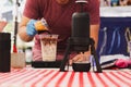 Barista pouring espresso shot into a glass of cold fresh milk. Royalty Free Stock Photo