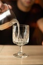 Barista pouring frothed milk into a latte glass.