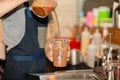 Barista pouring iced chocolate into takeaway cup in cafe. Royalty Free Stock Photo