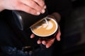 Barista pouring latte foam on coffee, espresso. creating a perfect latte art. dark colours, coffee house Royalty Free Stock Photo