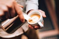 Barista pouring latte foam over coffee, espresso and creating a perfect cappuccino