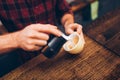 Professional barista pouring latte foam over coffee, espresso and creating a perfect delicious cappuccino