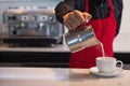 Barista pouring milk into cup of coffee Royalty Free Stock Photo