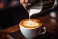 barista pouring milk in a cup of hot latte art coffee, Barista pouring milk into a cup of latte art coffee. A coffee cup in a Royalty Free Stock Photo