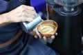 Barista pouring milk foam for making coffee latte art with pattern the leaves in a cup Royalty Free Stock Photo