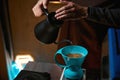 Barista pouring water over ground coffee beans contained in filter Royalty Free Stock Photo