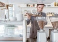 A barista pours coffee beans