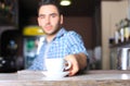 Barista prepares cappuccino in his coffee shop