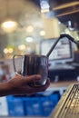 Barista prepares a cappuccino latte on a coffee machine in a cafe, steaming milk Royalty Free Stock Photo