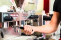 Barista preparing espresso at coffee maker