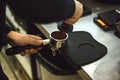 Barista presses ground coffee