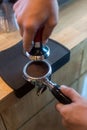 Barista pressing coffee in the machine holder. Coffee powder on coffee tamper. barista using tamper to press ground coffee into po Royalty Free Stock Photo