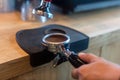 Barista pressing coffee in the machine holder. Coffee powder on coffee tamper. barista using tamper to press ground coffee into po Royalty Free Stock Photo