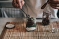 Barista putting red bean and pouring matcha latte from traditional japanese ceramic tool on top vanilla ice cream selective focus Royalty Free Stock Photo
