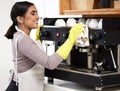 Barista, smile and wipe coffee machine in coffee shop, deli and cafe for sanitation, cleansing and dusting. Happy, woman