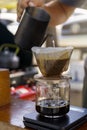 Barista spills hot water prepare filter coffee from stainless steel teapot to drip paper maker on black simple weights. Everything