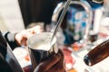 Barista steaming milk in coffee shop